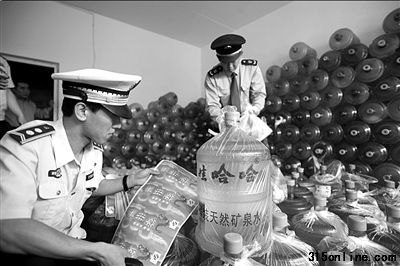 城管和工商人員正在清點現(xiàn)場的假冒桶裝水。本報通訊員姚震攝