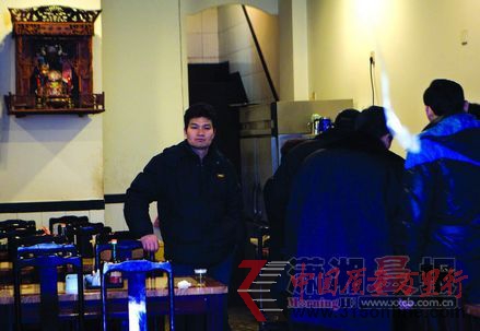 工作人員在忙著簽寫整改通知書,門店老板李明生站在身后一臉苦悶。圖/記者辜鵬博
