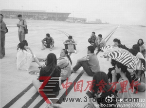 6日早上,部分滯留乘客進入昆明機場停機坪,坐在飛機跑道上,不愿離開。 6日早上,部分滯留乘客進入昆明機場停機坪,坐在飛機跑道上,不愿離開。