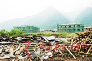 圖為:在秦嶺北麓圭峰山腳下原“優勝美地”別墅區已拆除的違章別墅廢墟之上,新的開發商已經開始對部分未拆除別墅進行外觀改造(8月9日攝)。